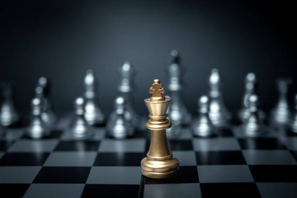 Golden King chess standing in front on board game. Concept leadership strategy business.